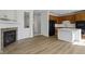 Modern kitchen seamlessly connects to the living area, featuring light wood floors and a decorative fireplace at 9417 Glencroft Way, Indianapolis, IN 46250
