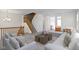 Open-concept living room with modern furniture, plush carpeting, and a staircase at 9417 Glencroft Way, Indianapolis, IN 46250