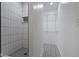Walk-in shower with modern white tile and stylish closet featuring custom shelving at 9417 Glencroft Way, Indianapolis, IN 46250