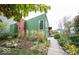 Unique home with a green exterior, interesting landscaping, and a wooden walkway leading to the front door at 949 Harrison St, Indianapolis, IN 46202