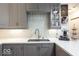 Close up of kitchen with quartz countertops, tile backsplash, stainless steel sink and gray cabinets at 949 Harrison St, Indianapolis, IN 46202
