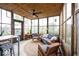 Cozy sunroom with wooden floors and furniture, a ceiling fan and lots of natural light at 949 Harrison St, Indianapolis, IN 46202