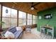 A sunroom with natural light, ceiling fan, and wooden furniture at 949 Harrison St, Indianapolis, IN 46202