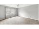This is a bedroom with neutral walls, plush carpeting, a ceiling fan, and large window at 9553 Maple Way, Indianapolis, IN 46268