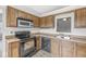 Traditional kitchen featuring wood cabinets, black appliances and laminate countertops at 9553 Maple Way, Indianapolis, IN 46268