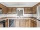 The kitchen features classic wood cabinetry, ample counter space and a stainless steel refrigerator at 9553 Maple Way, Indianapolis, IN 46268