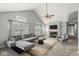 Sun-filled living room with vaulted ceiling, fireplace, built-in shelving and large windows at 9553 Maple Way, Indianapolis, IN 46268