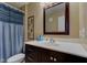 Bathroom vanity area showing dark cabinets, vanity mirror, shower curtain at 9602 Sweet Clover Way, Fishers, IN 46038