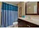 Bathroom vanity with dark cabinets, framed mirror, and blue shower curtain at 9602 Sweet Clover Way, Fishers, IN 46038