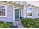 Close-up of front door with green paint, decorative sidelight, and neat landscaping at 9602 Sweet Clover Way, Fishers, IN 46038