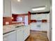 Well-lit kitchen featuring white cabinets, laminate countertops, and wood-look floors at 9602 Sweet Clover Way, Fishers, IN 46038