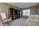 Living room features bookshelves, rocker, neutral walls, and carpet floors at 9602 Sweet Clover Way, Fishers, IN 46038