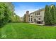 Large, lush backyard with expansive lawn, patio, and outdoor dining set perfect for entertaining at 9656 Loganberry Ln, Indianapolis, IN 46256