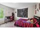 Charming bedroom with a colorful tapestry, desk near window, and red and black striped comforter at 9656 Loganberry Ln, Indianapolis, IN 46256