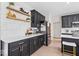 Modern kitchen with dark cabinetry, stainless steel appliances, and quartz countertops at 9656 Loganberry Ln, Indianapolis, IN 46256