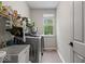 Laundry room has stainless steel washer/dryer and open shelving with window overlooking backyard at 9656 Loganberry Ln, Indianapolis, IN 46256