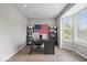 Well-lit home office with a bay window, modern desk, and patriotic American flag decoration at 9656 Loganberry Ln, Indianapolis, IN 46256