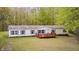 Inviting single-story home with a cozy front porch and a well-maintained lawn surrounded by lush greenery at 9660 Old Haggard Rd, Morgantown, IN 46160