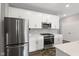 Well-equipped kitchen boasts stainless steel appliances, white cabinetry, and a tiled backsplash, blending style and functionality at 9696 Parkhurst Xing, McCordsville, IN 46055