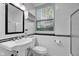 Clean bathroom with a pedestal sink, ceramic tile and a bright window view at 9806 Raintree N Dr, Columbus, IN 47201