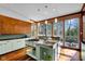 Bright kitchen featuring stainless steel island with cooktop, sink, and large windows offering scenic backyard views at 9806 Raintree N Dr, Columbus, IN 47201