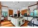 Open kitchen boasts modern appliances, granite countertops, hardwood floors, and a spacious center island with cooktop at 9806 Raintree N Dr, Columbus, IN 47201