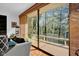 Cozy living area featuring a comfortable sofa, large sliding glass doors leading to a wood deck and wood floors at 9806 Raintree N Dr, Columbus, IN 47201