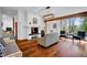 Inviting living room with hardwood floors, a cozy fireplace, and large windows bringing in natural light at 9806 Raintree N Dr, Columbus, IN 47201