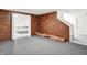 Partially finished basement space featuring brick accent wall, stairs, and potential rec area at 10746 Gateway Dr, Fishers, IN 46037