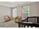 Bedroom featuring neutral walls, two windows and two accent chairs, and a crib at 10746 Gateway Dr, Fishers, IN 46037