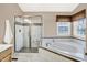 Main bathroom boasts tile floors, tub with tile surround, and separate glass enclosed shower at 10746 Gateway Dr, Fishers, IN 46037