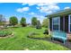Charming backyard featuring lush lawn, landscaping beds, a cozy bench, and views of surrounding homes at 10992 Chapel Woods S Blvd, Noblesville, IN 46060