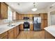 Well-lit kitchen featuring stainless steel appliances, white counters, and abundant wood cabinetry at 10992 Chapel Woods S Blvd, Noblesville, IN 46060