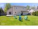 Spacious backyard with lush green grass, mature trees, a wooden deck, and firepit perfect for outdoor living at 11424 Geist Valley Dr, Indianapolis, IN 46236