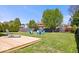 Large backyard with well-maintained lawn, mature trees, a wooden deck, and firepit area at 11424 Geist Valley Dr, Indianapolis, IN 46236