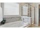 Luxurious bathroom featuring a soaking tub, glass-enclosed shower, and neutral tile at 1275 Cliff View Dr, Westfield, IN 46074