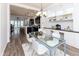 Bright dining room with a glass table, white chairs, built-in workstation and kitchen views at 13323 Susser Way, Fishers, IN 46037