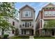 Charming three-story home with a balcony, complemented by manicured landscaping and vibrant greenery at 13323 Susser Way, Fishers, IN 46037