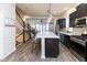 Modern kitchen with stainless steel appliances, dark cabinets, a large center island, and wood flooring at 13323 Susser Way, Fishers, IN 46037