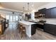 Modern kitchen with stainless steel appliances, dark cabinets, a large center island, and wood flooring at 13323 Susser Way, Fishers, IN 46037