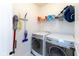 A functional laundry room featuring a washer, dryer, storage shelf with cleaning supplies, and other cleaning equipment at 13323 Susser Way, Fishers, IN 46037
