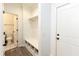 Functional mudroom with built-in storage, a bench, and a view into a half bathroom at 13323 Susser Way, Fishers, IN 46037