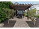 A beautiful wooden pergola with a dining table set, decorative lighting, and a paved patio at 13323 Susser Way, Fishers, IN 46037
