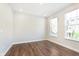 Bright, empty room with hardwood floors and large windows offers versatile living space at 13776 Tender Dr, Carmel, IN 46032