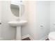 Modern powder room with pedestal sink, round mirror, and stylish fixtures at 13776 Tender Dr, Carmel, IN 46032
