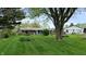 Lush backyard features mature trees, a sun room, and green grass at 1402 Arcola Ct, Beech Grove, IN 46107