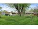 Expansive backyard featuring lush green lawn, mature trees, and storage sheds at 1402 Arcola Ct, Beech Grove, IN 46107