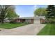 A lovely brick home featuring an attached garage, American flag, and well-kept lawn at 1402 Arcola Ct, Beech Grove, IN 46107