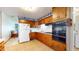 Functional kitchen featuring wood cabinetry, updated appliances, and tile backsplash at 1402 Arcola Ct, Beech Grove, IN 46107