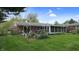 Rear exterior of home featuring a screened-in porch and well-maintained landscaping at 1402 Arcola Ct, Beech Grove, IN 46107